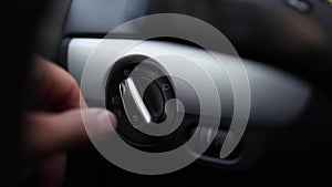 Close-up of male hand turn off and auto mode of switch light button of car