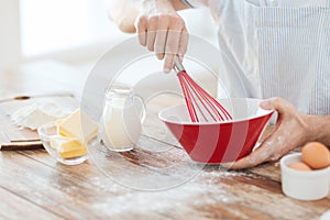 Close up of male hand whisking something in a bowl