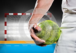 Close-up of male handball player holding ball against goal post