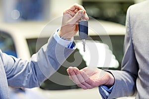 Close up of male hands with car key in auto salon