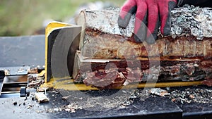 Close up of male hands chopping birch firewood on a hydraulic wood splitter. Sawmill. Birch firewood for fireplac