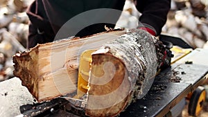 Close up of male hands chopping birch firewood on a hydraulic wood splitter. Sawmill. Birch firewood for fireplac