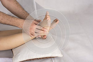 Close-up of male hands doing foot massage