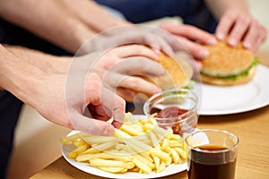 Close up of male hands with fast food on table