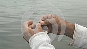 Close up of male hands with fishing gear. Fisherman preparing fishing bait for fishing. Fishing lifestyle concept. Fishing on lake