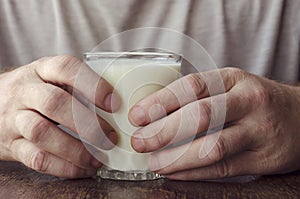 Close-up of male hands with full glass of kefir