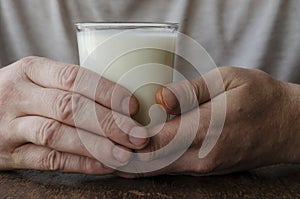 Close-up of male hands with full glass of kefir