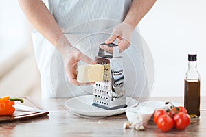 Close up of male hands grating cheese