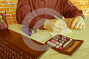 Close up of male hands on her calculator`s keyboard. The second hand in on the touchpad. Concept of accountant`s work