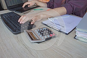 Close up of male hands on her calculator`s keyboard. The second hand in on the touchpad. Concept of accountant`s work