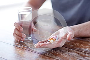 Close up of male hands holding pills and water