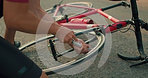 close-up male hands inflate wheel of broken bike with hand pump