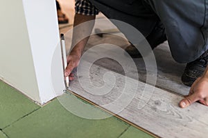 Close up of male hands intalling wood flooring