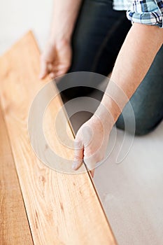 Close up of male hands intalling wood flooring