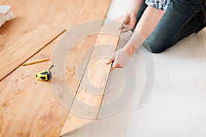 Close up of male hands intalling wood flooring