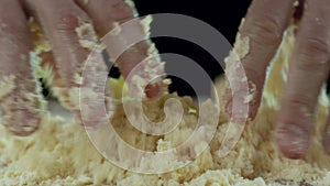 Close-up of male hands kneading dough on the kitchen table at kitchen