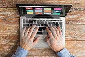 Close up of male hands with laptop typing