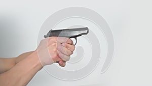 Close-up male hands making gun recharge aiming to target and press the trigger side view