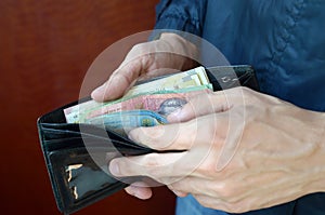 Close up male hands opened the wallet or purse with ukrainian money currency hryvnia