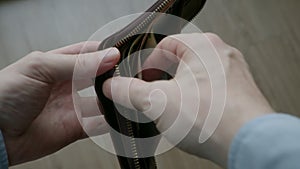 Close-up of male hands opening a wallet with EURO and euros inside. Financial crisis, poverty concept, payment for