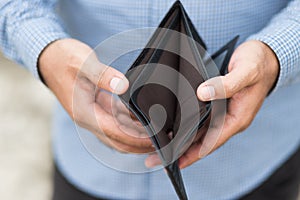 Close up male hands opening the wallet but no money in wallet. Financial concept