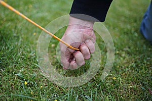 Close up of male hands pegging down a tent on grass.