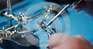 Close-up of a male hands soldering a video transmitter chip from an FPV drone.