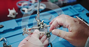 Close-up of a male hands soldering a video transmitter chip from an FPV drone.