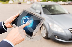 Close up of male hands with tablet pc and car