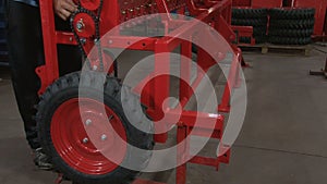 Close-up of male hands tightening a nut on a metal product. Technician in factory at machine maintenance working with wrench