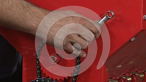 Close-up of male hands tightening a nut on a metal product. Technician in factory at machine maintenance working with wrench