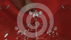 Close-up of male hands tightening a nut on a metal product. Technician in factory at machine maintenance working with wrench