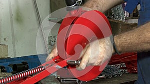 Close-up of male hands tightening a nut on a metal product. Technician in factory at machine maintenance working with wrench