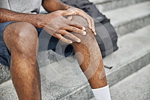 Close up of male hands touching knee