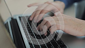 Close up male hands typing on keyboard Blurry background. Fingers on keyboard. Camera is moving