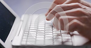 Close-up of male hands typing laptop keyboard