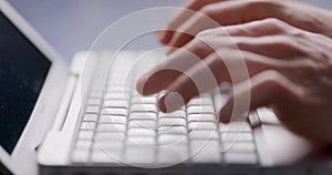 Close-up of male hands typing laptop keyboard