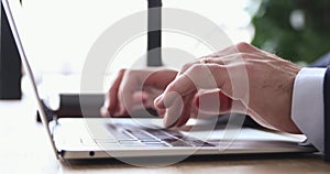 Close up male hands typing message on laptop keyboard.