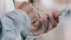 Close-up male hands of unrecognizable african american man holding telephone typing message chatting social network