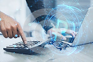 Close up of male hands using laptop and calculator with creative ruble hologram on blurry office desk background. Crypto, online