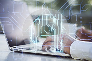 Close up of male hands using laptop on desktop with coffee cup and creative house chip circuit hologram on blurry background.