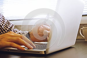 Close up of male hands using Laptop and holding credit card on the desk.