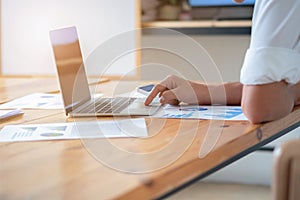 Close-up of male hands using laptop, man`s hands typing on laptop keyboard, side view of businessman using computer in meeting