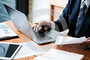 Close-up of male hands using laptop, man`s hands typing on laptop keyboard, side view of businessman using computer in meeting