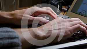 Close up of male hands using laptop at office, man`s hands typing on laptop keyboard in interior,, side view of