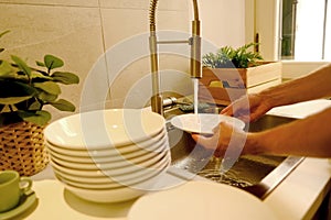 close-up male hands washing dishes, young man doing household chores in modern kitchen, concept Kitchen Hygiene, Water