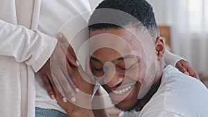 Close-up male head loving caring afro american black ethnic husband father hugs embraces touching listening pregnant