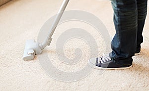 Close up of male hoovering carpet