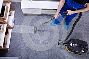 Janitor Cleaning Carpet With Vacuum Cleaner