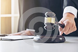 Close up of Male lawyer or judge hand`s striking the gavel on so